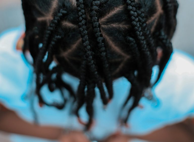 Close-up of clean cornrow parting showing tension-free braid roots, protective styles San Diego