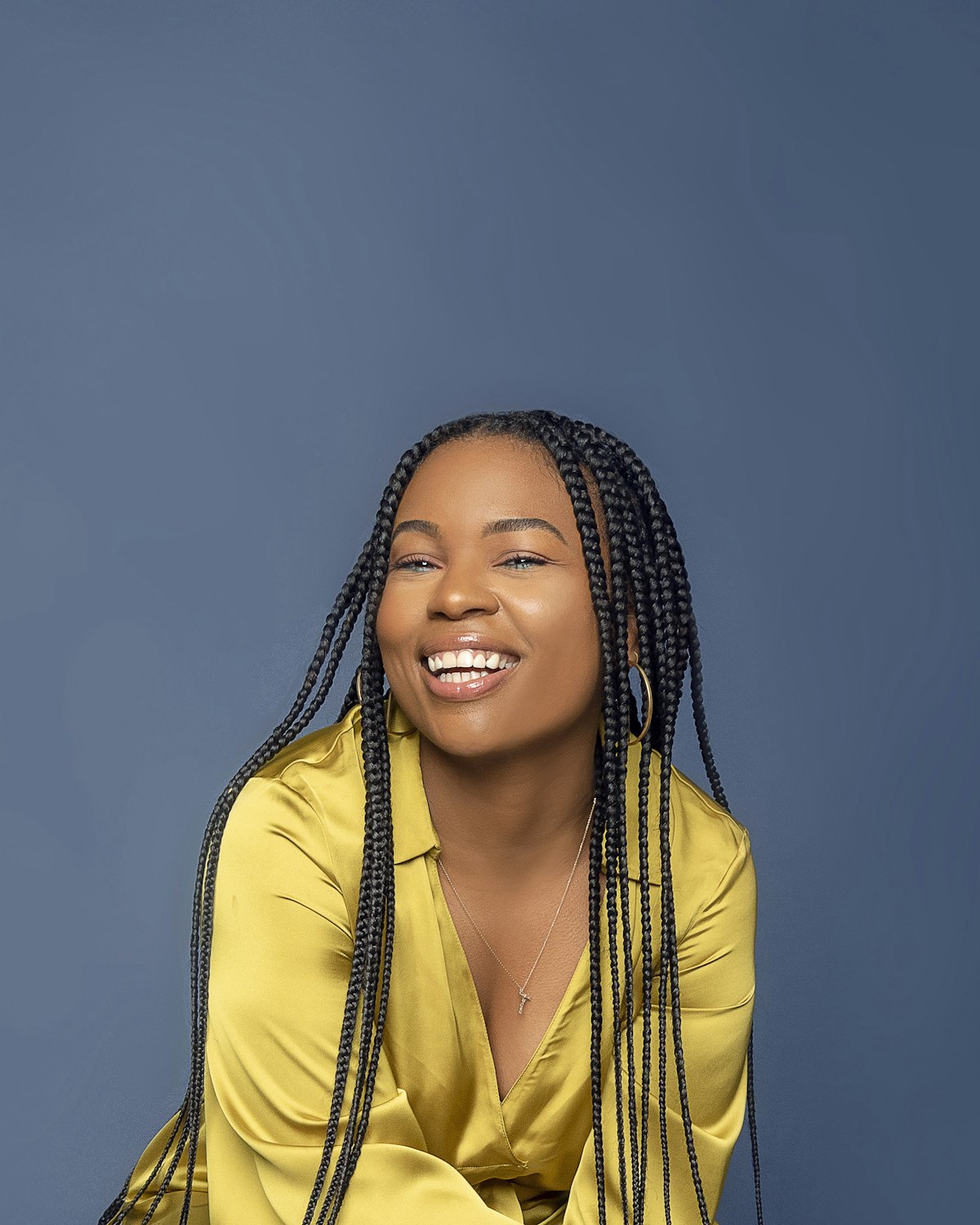 Smiling client wearing long braids at a braiding salon in San Diego