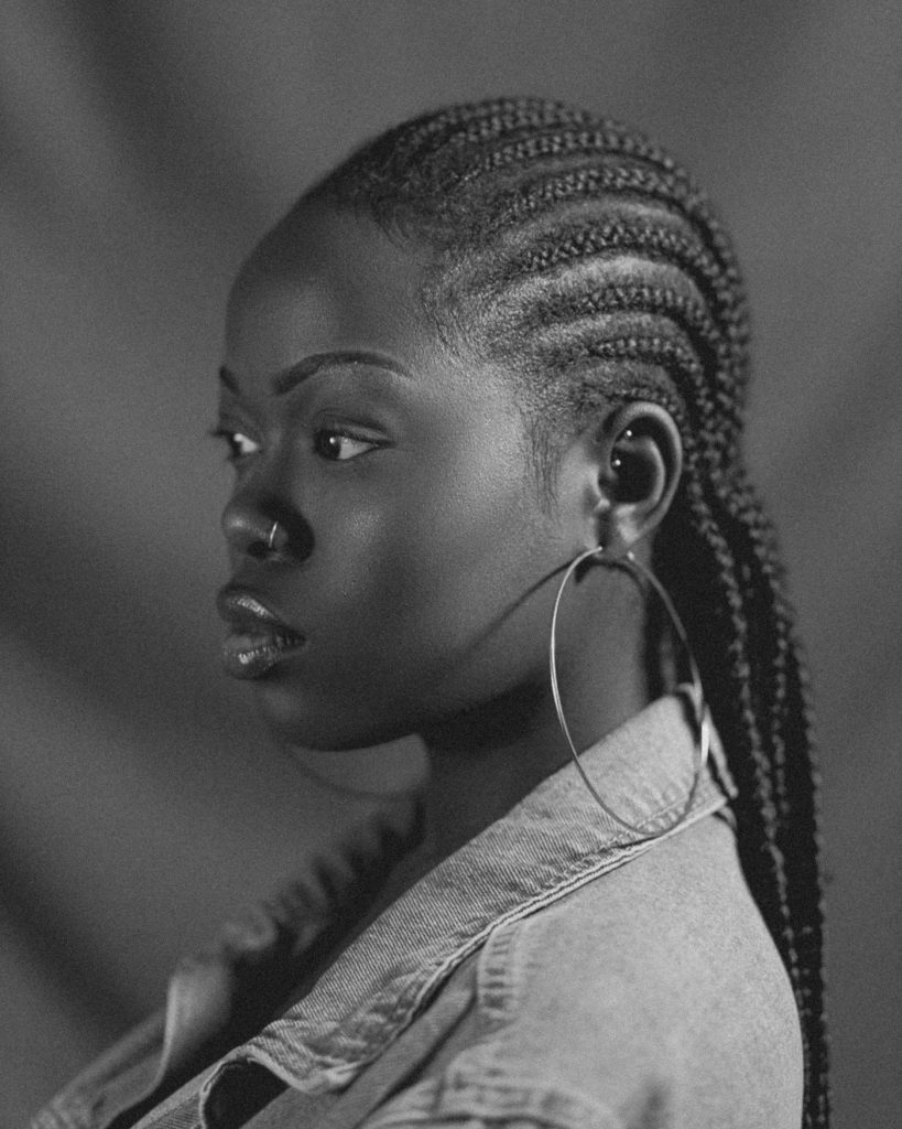 Profile view of feed-in braids with gold hoop earrings, feed-in braids San Diego
